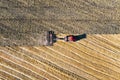 Aerial view on the combine working on the large wheat field. Haymaking and harvesting in early autumn on the field. Tractor mows