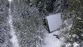 Aerial view of coniferous winter forest and a small glamp house. Clip. Flying above frozen trees and snow covered ground Royalty Free Stock Photo