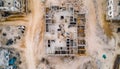 aerial view of a construction site showing the early stages of a building with concrete walls and surrounding dirt roads and rubbl Royalty Free Stock Photo