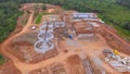Aerial view of a construction site with trailers unloading raw m