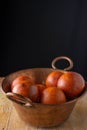 Aerial view of copper bowl with blood oranges on rustic wooden table, with black background, Royalty Free Stock Photo