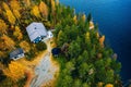 Aerial view of cottage in autumn colors forest by blue lake in rural Finland Royalty Free Stock Photo
