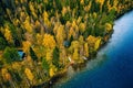 Aerial view of cottage in autumn colors forest by blue lake in rural Finland Royalty Free Stock Photo