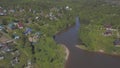 Aerial view of cottage village and houses near the large river surrounded by coniferous and deciduous trees in warm Royalty Free Stock Photo