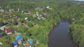 Aerial view of cottage village and houses near the large river surrounded by coniferous and deciduous trees in warm Royalty Free Stock Photo