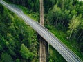 Aerial view of country road above the railway in a green summer forest Royalty Free Stock Photo