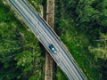 Aerial view of country road above the railway in a green summer forest Royalty Free Stock Photo