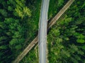 Aerial view of country road above the railway in a green summer forest Royalty Free Stock Photo