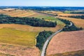 Aerial view of a country road amid fields against blue clear sky Royalty Free Stock Photo
