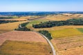 Aerial view of a country road amid fields against blue clear sky Royalty Free Stock Photo