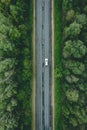 Aerial view of country road with car driving through green forest and corn fields Royalty Free Stock Photo