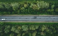 Aerial view of country road with car driving through green forest and corn fields Royalty Free Stock Photo