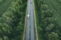 Aerial view of country road with car driving through green forest and corn fields Royalty Free Stock Photo