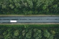 Aerial view of country road with car driving through green forest and corn fields Royalty Free Stock Photo