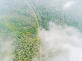 Aerial view of a country road in the forest. Beautiful landscape. Clouds over the green forest and road. Aerial bird`s eye road. Royalty Free Stock Photo