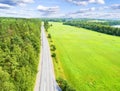 Aerial view of a country road in the forest with moving cars. Landscape. Captured from above with a drone. Aerial bird`s eye road Royalty Free Stock Photo