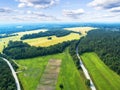 Aerial view of a country road in the forest with moving cars. Landscape. Captured from above with a drone. Aerial bird`s eye road Royalty Free Stock Photo