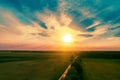 Aerial view of a country road through the green fields at sunset Royalty Free Stock Photo