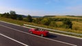 Aerial View Of Couple Driving Red Convertible Sports Car Down Country Road. Royalty Free Stock Photo