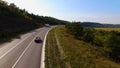 Aerial View Of Couple Driving Red Convertible Sports Car Down Country Road. Royalty Free Stock Photo