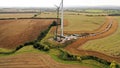 Aerial view of cranes installing new blades on a wind turbine.