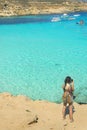 Aerial view on crystal clear turquoise water sea Blue lagoon in Malta. Young backpacker girl photographing azure ocean with sand d