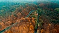 Aerial view of curvy road in beautiful autumn foggy forest . Top view of roadway with autumn colors. Europe roads and Royalty Free Stock Photo