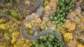 Aerial view of curvy road in forest. Autumn high in mountains. Cars passing each other Royalty Free Stock Photo