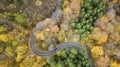 Aerial view of curvy road in forest. Autumn high in mountains. Cars passing each other Royalty Free Stock Photo