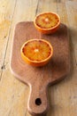 Aerial view of cutting board with two orange halves, on rustic table Royalty Free Stock Photo