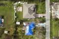 Aerial view of damaged in hurricane Ian house roof covered with blue protective tarp against rain water leaking until Royalty Free Stock Photo