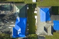 Aerial view of damaged in hurricane Ian house roof covered with blue protective tarp against rain water leaking until Royalty Free Stock Photo