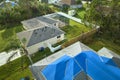 Aerial view of damaged in hurricane Ian house roof covered with blue protective tarp against rain water leaking until Royalty Free Stock Photo