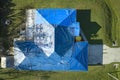 Aerial view of damaged in hurricane Ian house roof covered with blue protective tarp against rain water leaking until Royalty Free Stock Photo