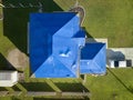 Aerial view of damaged in hurricane Ian house roof covered with blue protective tarp against rain water leaking until Royalty Free Stock Photo