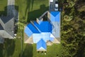 Aerial view of damaged in hurricane Ian house roof covered with blue protective tarp against rain water leaking until Royalty Free Stock Photo