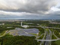 Aerial view of dark storm clouds over panels at small solar farm next to highway Royalty Free Stock Photo