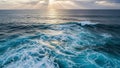 Aerial view of deep blue ocean waves crashing with white foam under dramatic cloudy sky with sun rays breaking through the clouds Royalty Free Stock Photo