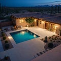 An aerial view of a desert landscaped backyard in Arizona featuring a travertine pool deck and fireplace.