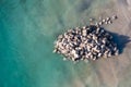 Aerial view directly above a stack of stone rocks from a quarry in the ocean