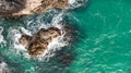 Aerial view directly above waves crashing onto rocky cliffs in Cornwall Royalty Free Stock Photo