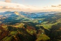 Aerial view of distant village with small shepherd houses on wide hill meadows between autumn forest trees in Ukrainian Carpathian Royalty Free Stock Photo
