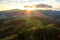 Aerial view of distant village with small shepherd houses on wide hill meadows between autumn forest trees in Ukrainian Carpathian Royalty Free Stock Photo