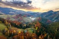 Aerial view of distant village with small shepherd houses on wide hill meadows between autumn forest trees in Ukrainian Carpathian Royalty Free Stock Photo