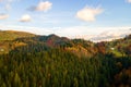 Aerial view of distant village with small shepherd houses on wide hill meadows between autumn forest trees in Ukrainian Carpathian Royalty Free Stock Photo