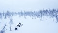 Aerial view of dogsledding in the arctic winter of Finnish Lapland.