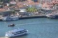 Aerial view at the Douro river, with cruisers and recreative boats, Gaia downtown buildings and ferris wheel as background