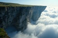 Aerial view of a dramatic cliff surrounded by clouds and mist, showcasing Royalty Free Stock Photo