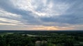 Aerial view dramatic storm sky landscape with sun rays between the clouds and over the forests. Dark moody cloudscape. Royalty Free Stock Photo