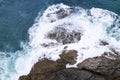 Aerial view Drone camera top down of seashore rocks in a blue ocean Turquoise sea surface Amazing sea waves crashing on rocks Royalty Free Stock Photo